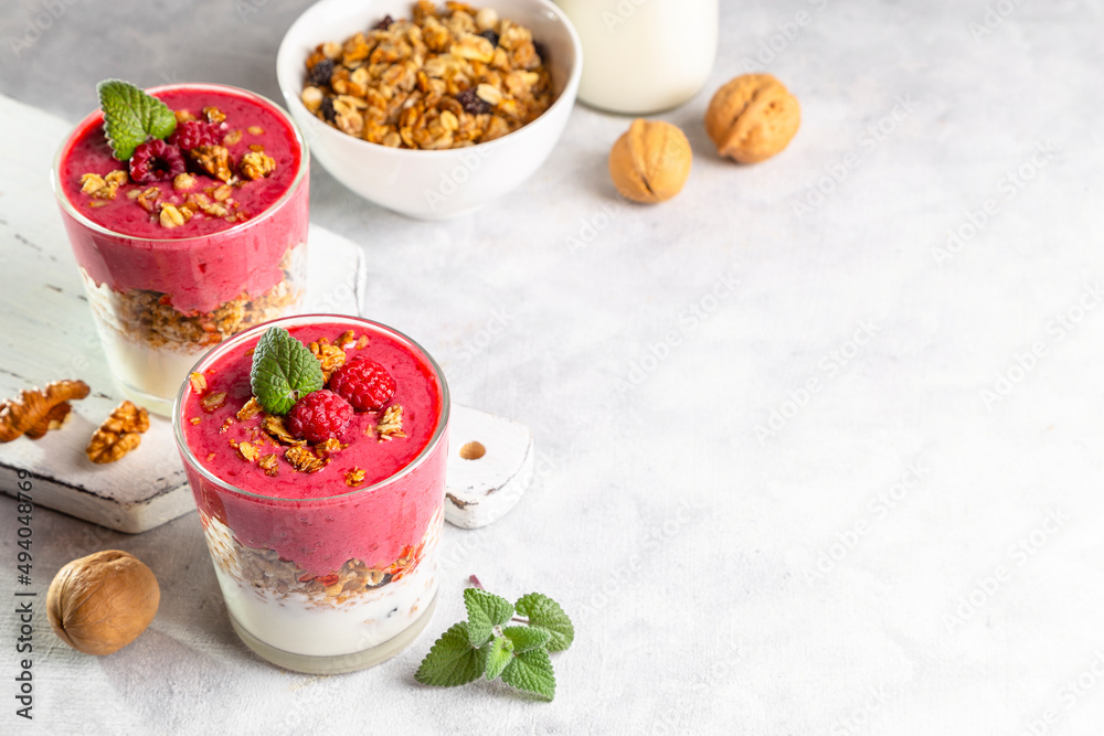 Yogurt, raspberry smoothie and homemade granola in a transparent glass. Healthy breakfast or snack. Copy space Yogurt, raspberry smoothie and homemade granola in a transparent glass. Healthy breakfast or snack. Copy space
