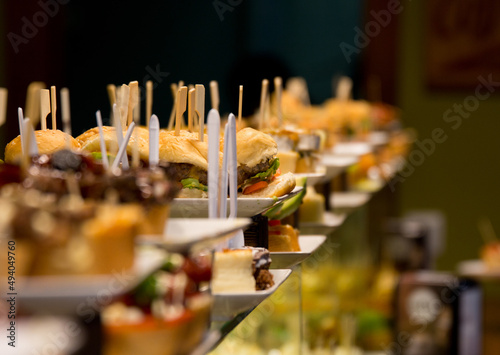 Closeup of the pinchos with wooden sticks on top. Catering products on the plates. photo