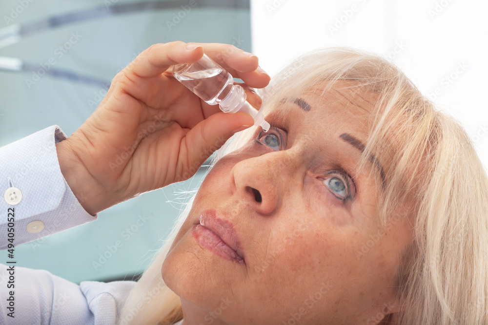 Senior woman drips eye drops into her eyes. Woman suffering from irritated eyes or eye diseases. Vision and ophthalmology medicine. Senior woman drips eye drops into her eyes. Woman suffering from irritated eyes or eye diseases. Vision and ophthalmology medicine.