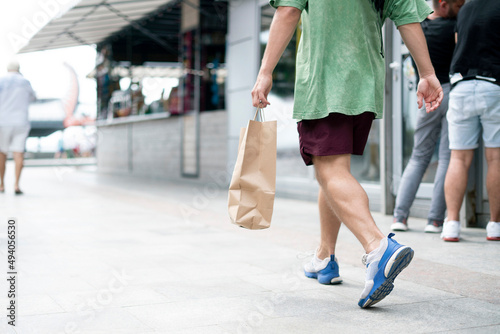 person carrying the paper bag with fresh food from the grocery store