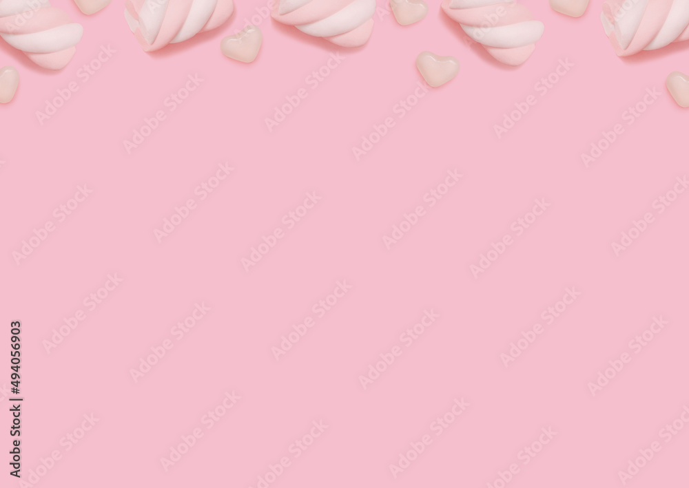 Candies. Design template with copy space. Swirl marshmallows and heart shaped lollipops on pastel pink backdrop