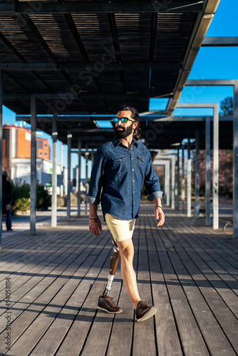 Man with bionic leg walking along street