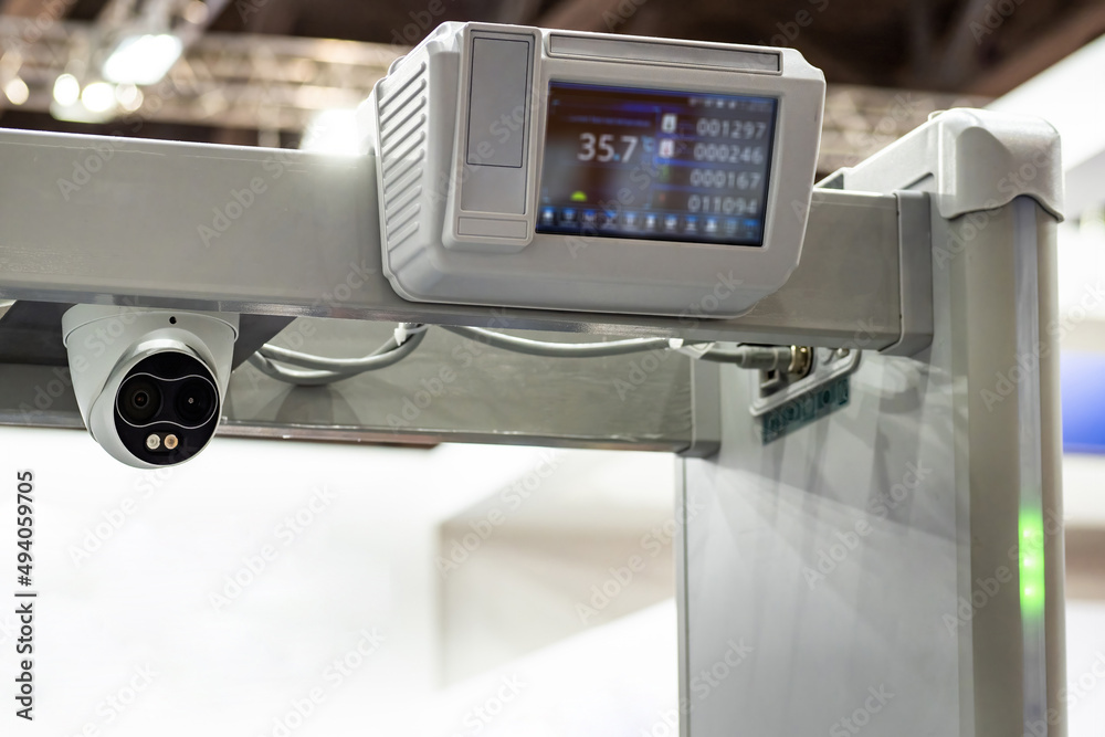 Metal detector frame with body temperature sensor. Fragment of arched metal detector close-up. Surveillance camera and temperature sensor on device for metal detection. Security technologies Metal detector frame with body temperature sensor. Fragment of arched metal detector close-up. Surveillance camera and temperature sensor on device for metal detection. Security technologies