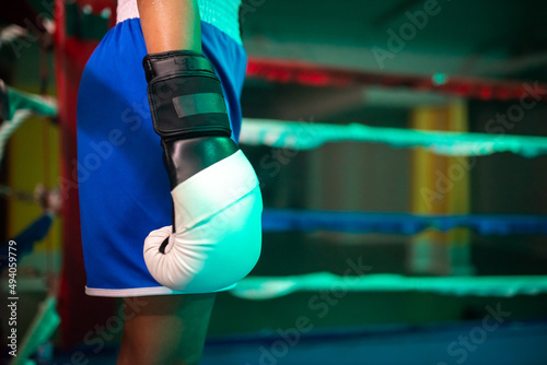 Close-up of boxer girls hand in glove. Young girl in sportswear relaxing before new boxing round with rival on ring, preparing to improve attack technique. Healthy lifestyle and womens boxing concept © KAMPUS