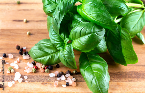 Photographie Green fresh basil on wooden background with pepper and himalayan salt
