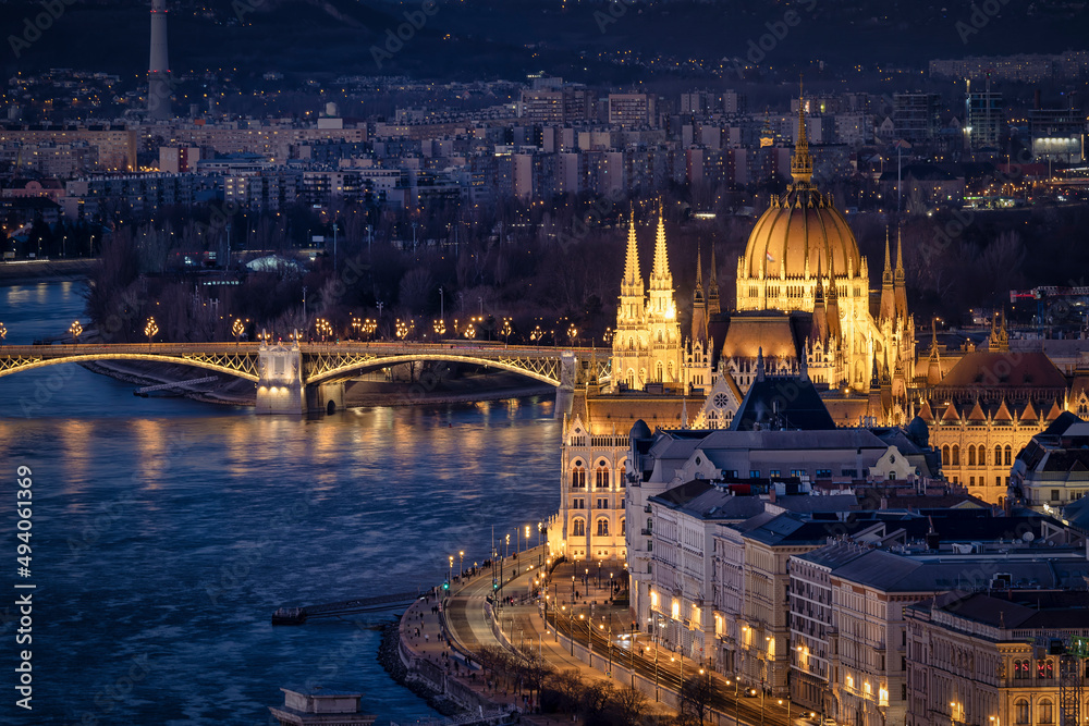 Naklejka premium Elevated night view of the illuminated Hungarian Parliament Building at river Danube in Budapest 