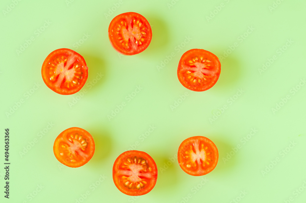 Fototapeta premium Cut tomatoes on green background