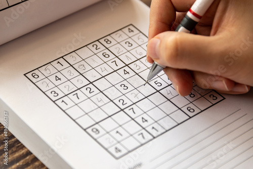 Εκτύπωση καμβά Person solving a sudoku puzzle on a wooden table