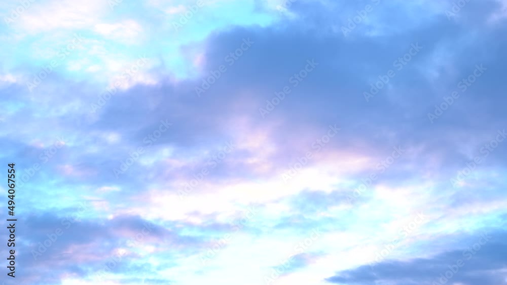 Beautiful evening blue sky at sunset with flaming bright light clouds. A warm summer evening at sunset. Bright sunset.