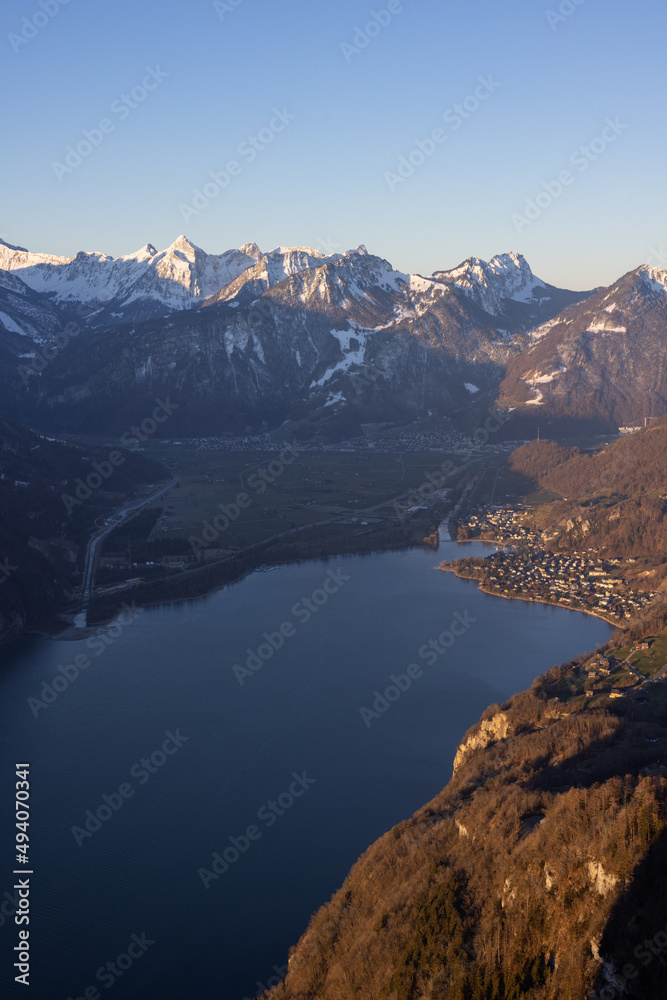 Great view on a beautiful morning over a lake called Walensee. The mountains in the background are illuminated by the morning sun.