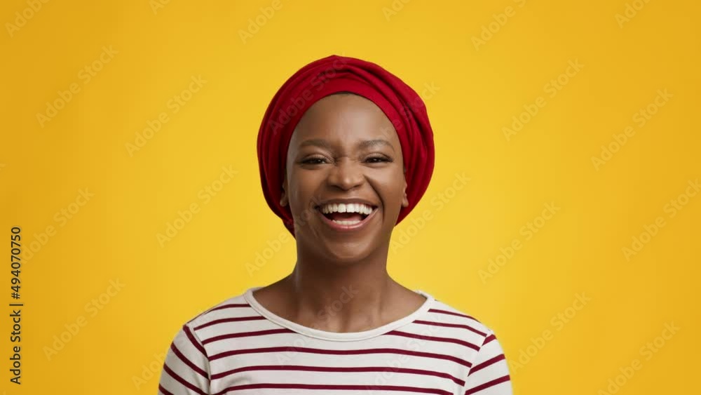 African Lady Smiling To Camera Wearing Red Headwrap, Yellow Background African Lady Smiling To Camera Wearing Red Headwrap, Yellow Background