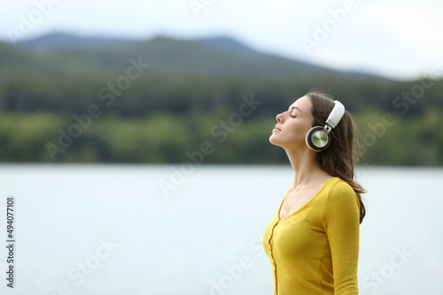 Woman meditating listening audio guide outdoors