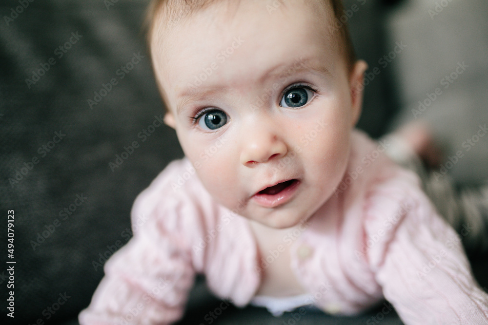 Cute baby girl in pink cardigan making a funny face Cute baby girl in pink cardigan making a funny face