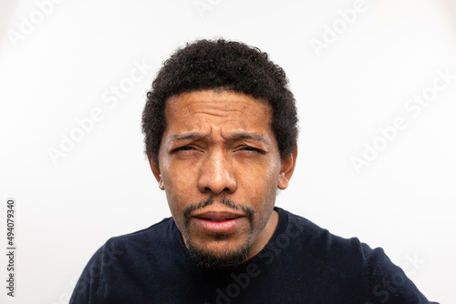 Myopic man without glasses straining his eyes because he can't see well