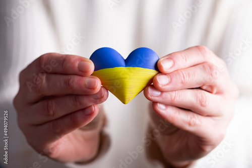 Heart flag of Ukraine in human hands. No war  peace for Ukraine concept.