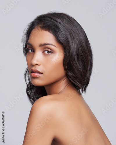 All natural beauty. Shot of a beautiful young posing over a gray background.