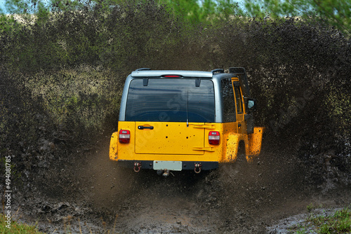 Yellow brazilian off-road sport truck splashing on a muddy puddle road