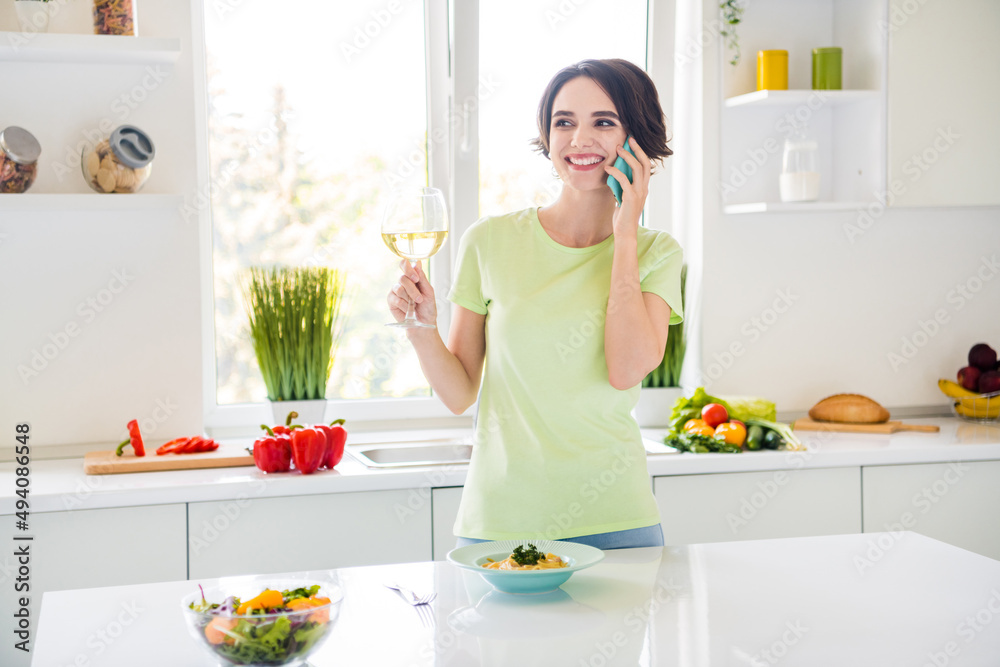 Portrait of cheerful pretty person hold wineglass speak telephone enjoy free time kitchen indoors