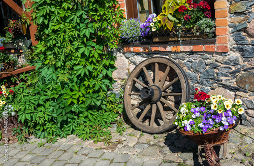 The wall of a stone house decorated with flowers in a retro style. Vertical gardening.