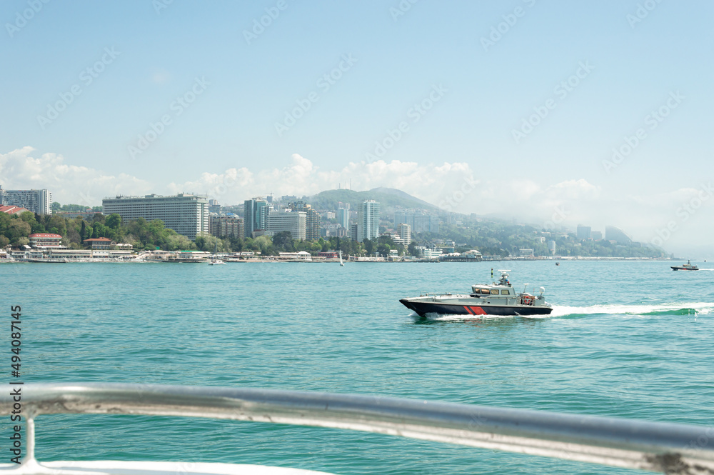 Obraz premium Motor ships and yachts on pier. Close-up. Wide landscape of the Black Sea. Sea trade port with mooring boats at sunset in Sochi, Russia