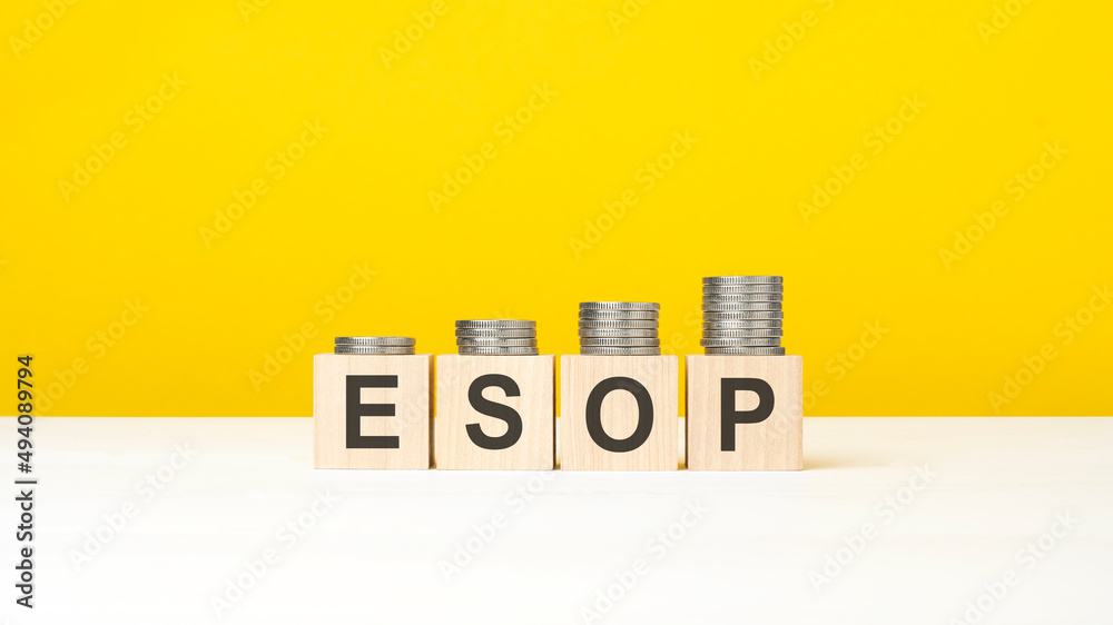 esop - word on wooden cubes, yellow background. growing trend