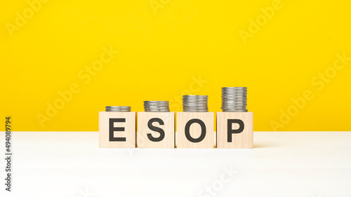 esop - word on wooden cubes, yellow background. growing trend photo