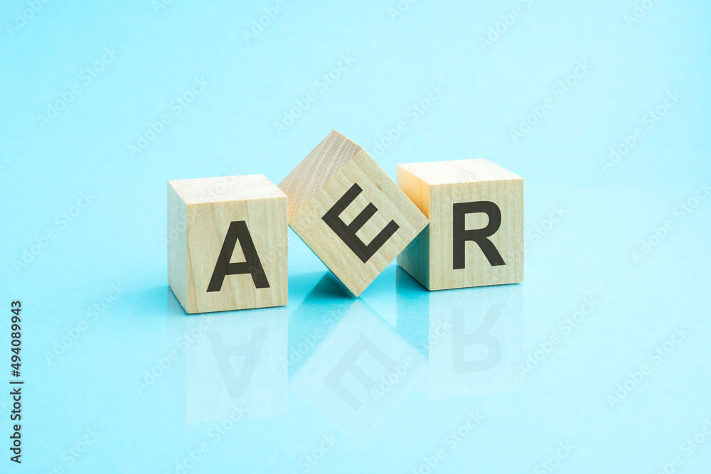 three wooden cubes with the letters AER on the bright surface of a blue table three wooden cubes with the letters AER on the bright surface of a blue table
