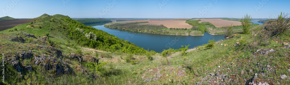 Amazing spring view on the Dnister River Canyon with picturesque rocks, fields, flowers. This place named Shyshkovi Gorby, Nahoriany, Chernivtsi region, Ukraine. Amazing spring view on the Dnister River Canyon with picturesque rocks, fields, flowers. This place named Shyshkovi Gorby, Nahoriany, Chernivtsi region, Ukraine.