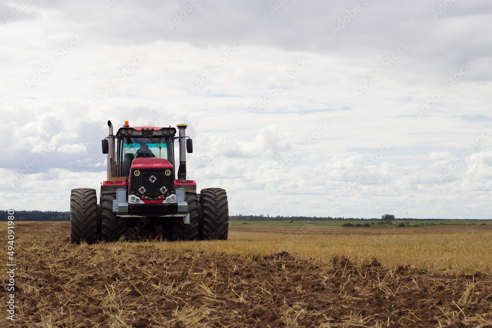 modern tractor in empty field with seasonal agriculture works modern tractor in empty field with seasonal agriculture works