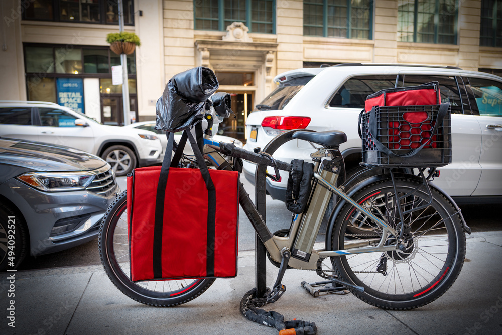 Electric food delivery bicycle locked to bike stand in Manhattan, New York City.