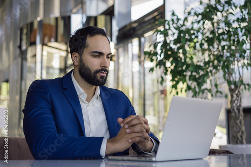 Εκτύπωση καμβά Handsome moroccan business man using laptop computer watching training courses working online in modern office