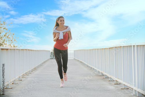 Fitness woman running on city road