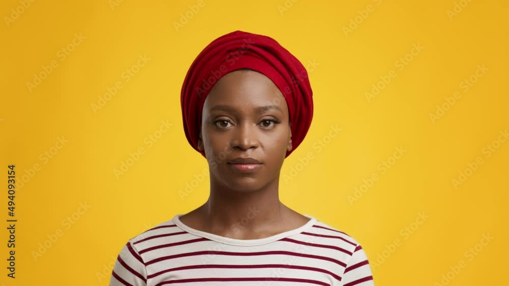 Portrait Of Serious African Lady Wearing Red Headwrap, Yellow Background Portrait Of Serious African Lady Wearing Red Headwrap, Yellow Background