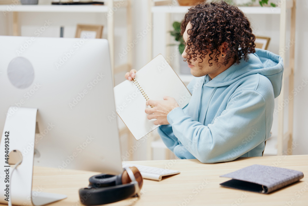 A young man sitting in front of the computer internet online technologies