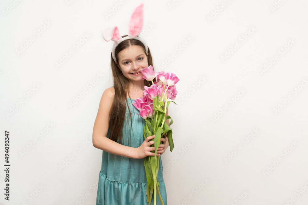 a happy little girl with long dark hair holds a bouquet of pink tulips in her hands and smiles looking at the camera, happy Easter, a happy little girl with long dark hair holds a bouquet of pink tulips in her hands and smiles looking at the camera, happy Easter,