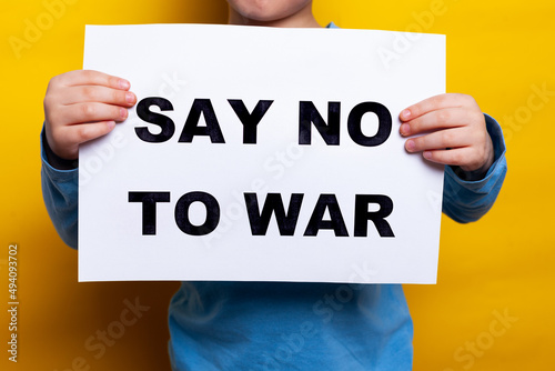 little boy, child with Ukrainian flag on cheeck isolated yellow background. Say no to war. Support Ukraine. Concept of protection, rights, independence, peace. High quality photo photo