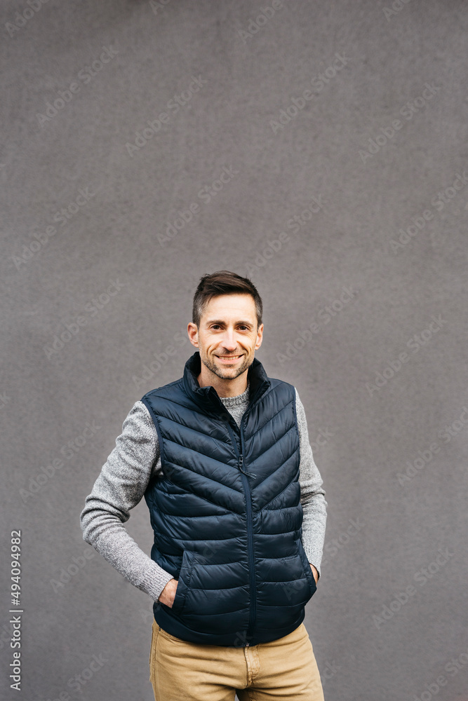 Portrait of a man in casual clothes, against a grey background