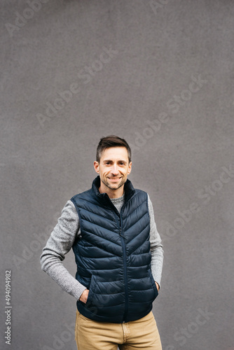 Portrait of a man in casual clothes, against a grey background