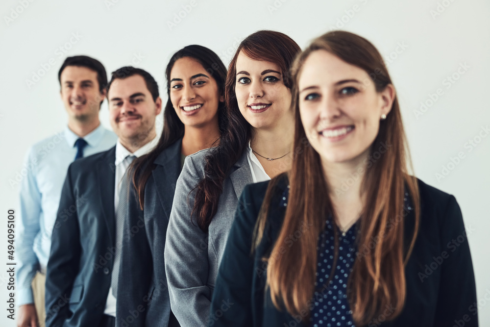 One team with one goal, success. Studio shot of a group of confident young businesspeople standing together in a row. One team with one goal, success. Studio shot of a group of confident young businesspeople standing together in a row.