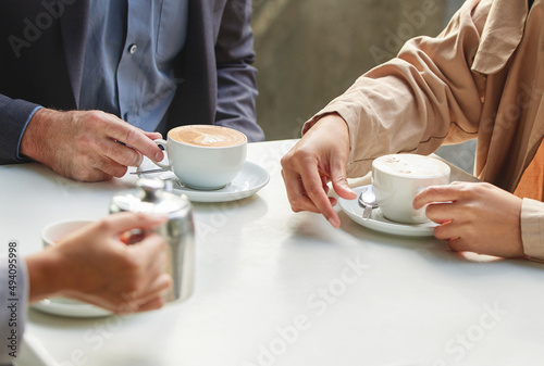 Give me your best shot. Shot of a group of coworkers having a meeting at a coffee shop.