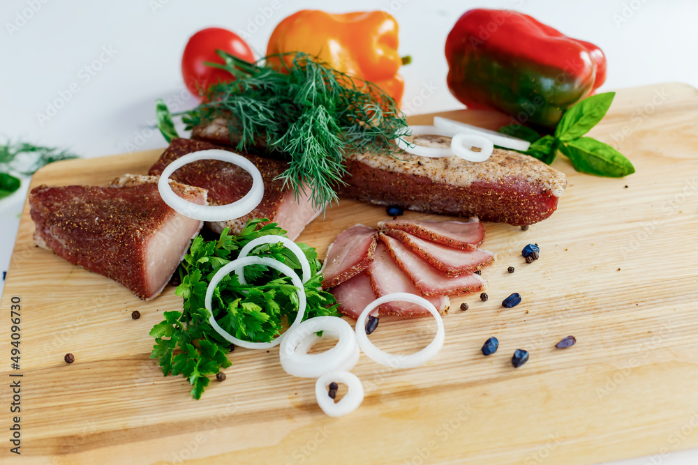 meat on a wooden board with vegetables meat on a wooden board with vegetables