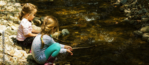 Tela Two little girl playing by forest stream on spring day