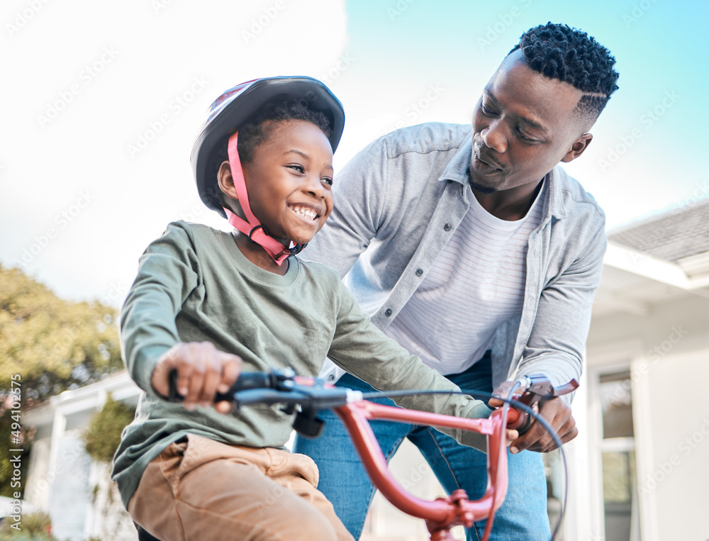 Obraz premium Look at him go. Shot of a father teaching his son to ride a bicycle outdoors.