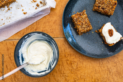 Homemade carrotcake bars with frosting and baking tray for breakfast or snack photo