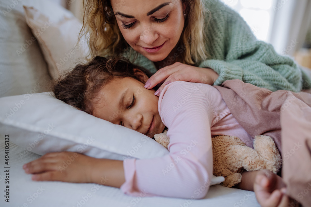 Happy mother stroking her little daughter when waking her up in morning. Happy mother stroking her little daughter when waking her up in morning.