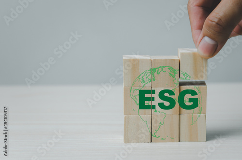 Hand put wooden cubes with ESG Environmental Social Governance symbol on table copy space.Business concepts.