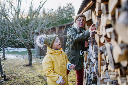 Boy with Down syndrome working in garden in winter with his grandmother.