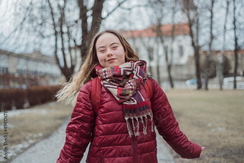 Young woman student with Down syndrome walking in street in winter photo