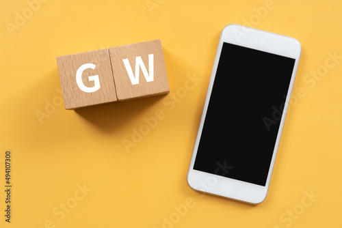 ゴールデンウィークのイメージ｜「GW」と書かれた積み木とスマホ #494107300