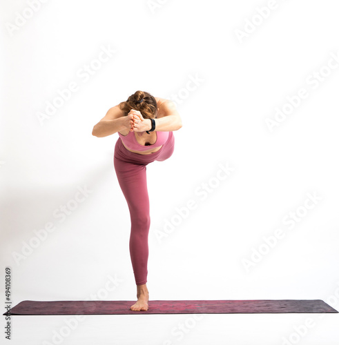 woman doing yoga on a white background virabhadrasana 3 warrior 3 pose photo